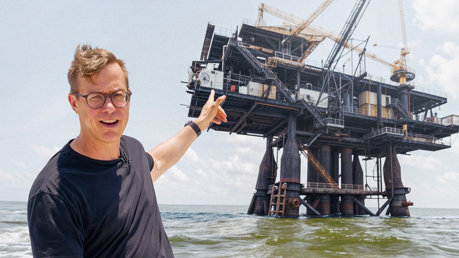 Nicholas Carlson reporting beside an offshore oil rig